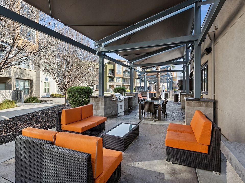 Aspire Apartments Tracy California Luxury Living A patio with black wicker furniture and orange cushions.