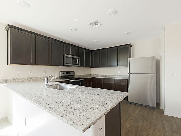 Upgraded kitchen with an undermount sink and espresso cabinetry.