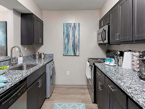 Explore this sleek kitchen designed with modern amenities and stylish finishes.