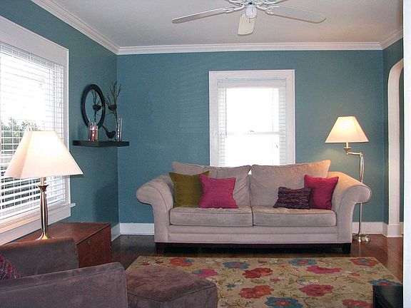 Living room also features a ceiling fan and big picture window.