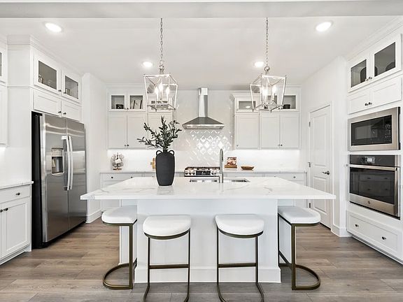 Kitchen with glass upper cabinets and pendant lighting