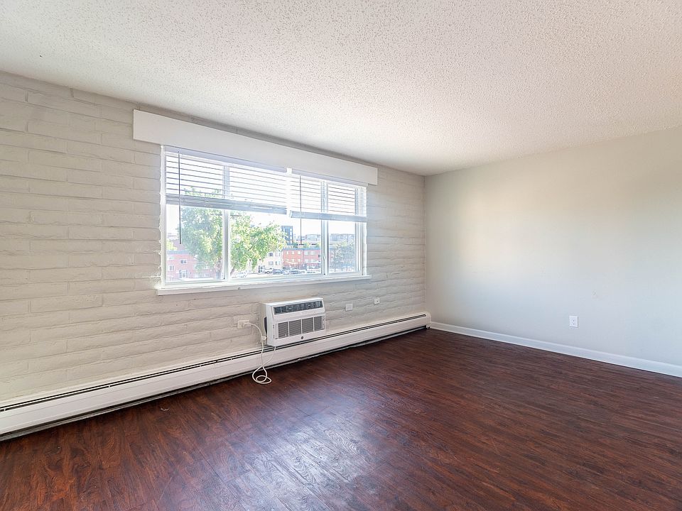 Bright living area with large window and elegant hardwood floors, offering a welcoming and spacious environment.