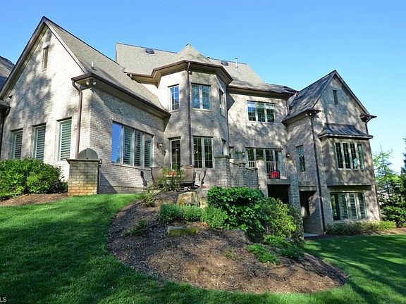The rear elevation shows the complex roof design and fenestration! Standing seam copper roofing on bay windows, twist and turns that translate inside into character is most rooms with nooks & crannies!