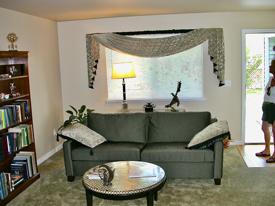 Living room with large bright windows and gas fireplace.