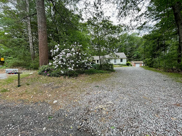 Front of driveway, mailbox on house side of street