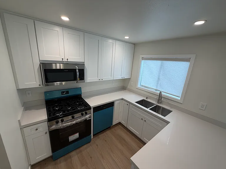 Kitchen shaker style cabinetry with brush nickel hardware and stainless steel appliances