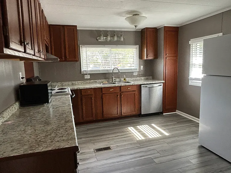 Stepping in to the Kitchen from the Dining Room with natural lighting in this photo