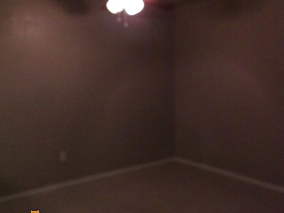 living room is all tile, has ceiling fan