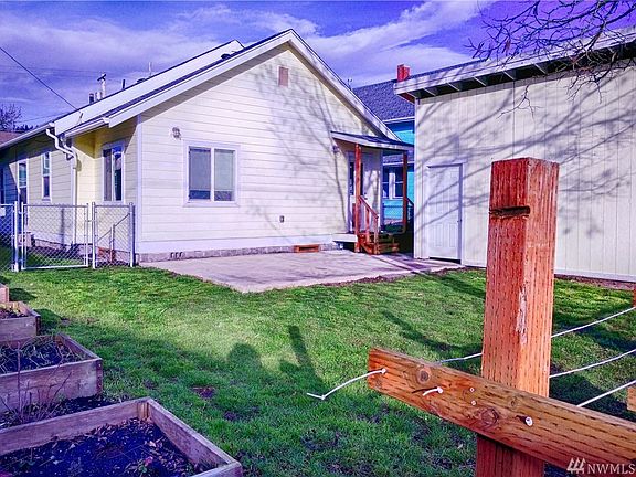 Fully fenced backyard offers generous patio to entertain and raised beds to garden.