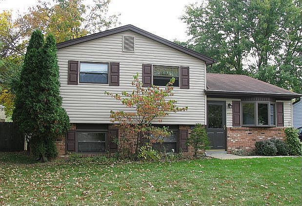 Front view: freshly powerwashed; blacktop driveway, bay window