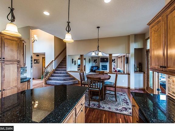 Stunning kitchen includes separate beverage fridge in island , tumbled stone backsplash and granite countertops