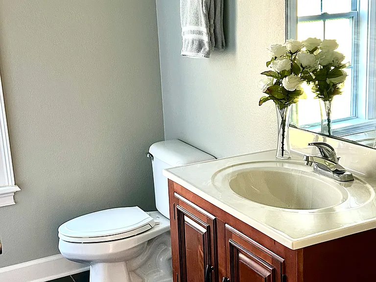 tiled floor, wood vanity and everything in perfect order in the second bathroom.