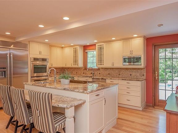 Handy breakfast bar, recessed lighting, beautiful cabinetry, hardwood floor, door to multi level deck and fenced in yard,
