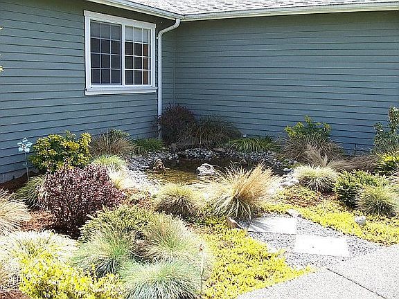 Another view of water feature and plants, sprinkler system in planter area.