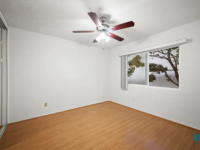 Bedroom with Mirrored Closet, Vinyl Flooring, Ceiling Fan, and Windows