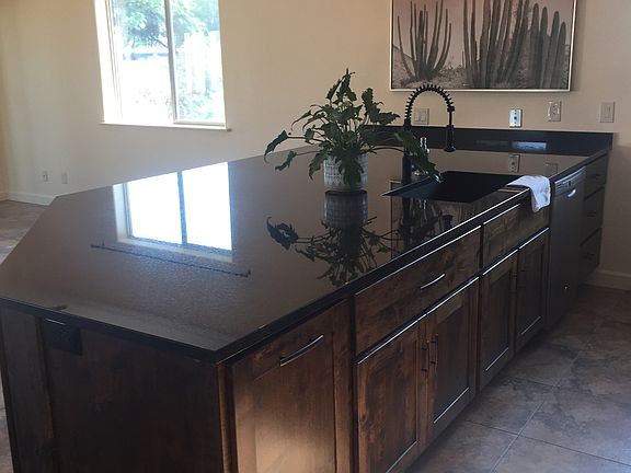 Giant granite island with custom cabinetry
 on all side for tons of kitchen and living room storage