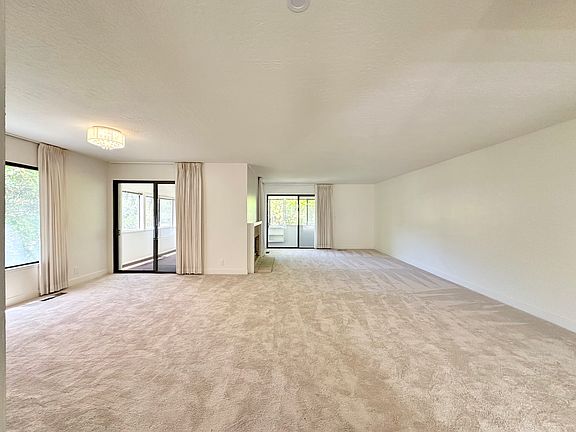 View from front door. Large living room + dining room combo. New carpets