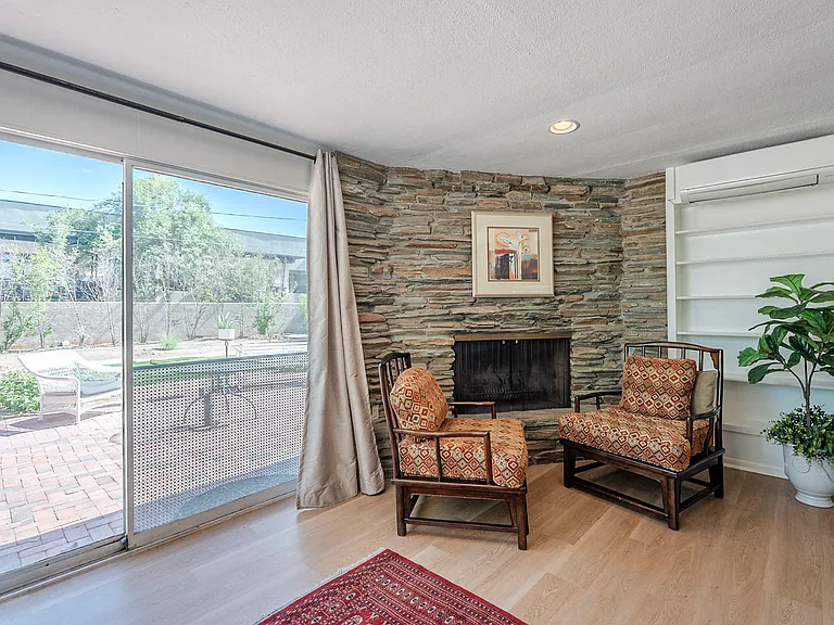 Sweet sitting area with access to backyard..open and waiting for a log in the fireplace!