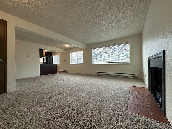 Large living room with brand new windows, a fireplace, and coat closet at the front entry