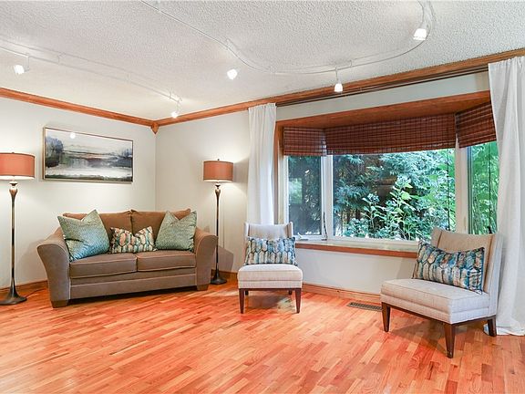 Gorgeous hardwood floors are sure to impress guests. Large bay windows allow the perfect amount of light! Notice the stunning woodwork wrapping around the ceiling, doorway, and bay window!