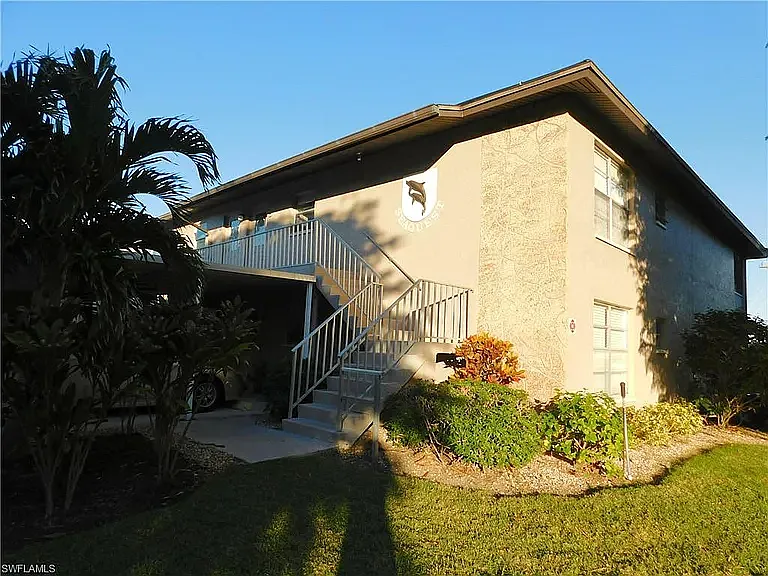 Front of building showing top right hand end unit of this lovely condo overlooking the pool and canal with your own boat dock! - 4563 SE 5th Pl #206