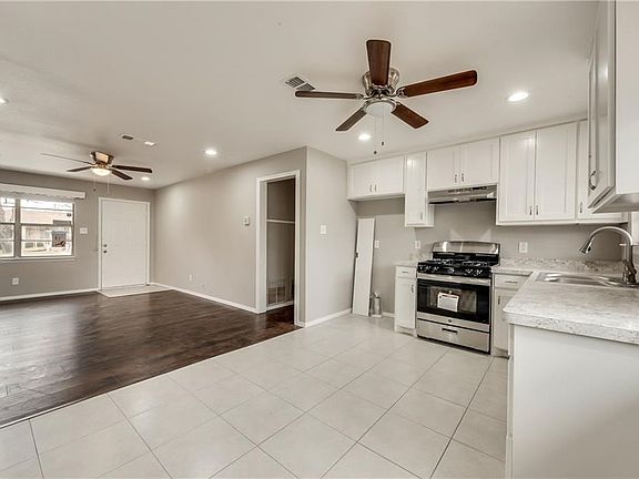 Kitchen is open to the living room and both areas have updated ceiling fans