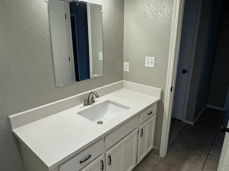 Middle bath vanity with new quartz, fixures.