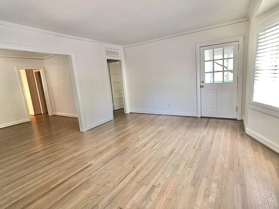 Large living room with bay window opens to dining then kitchen.