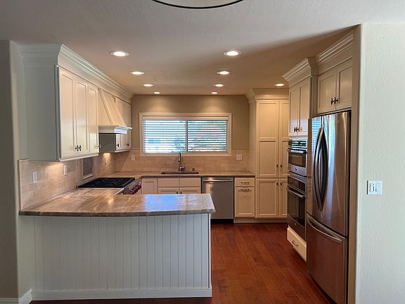 Custom kitchen cabinetry with stone countertops. Recessed lighting throughout.