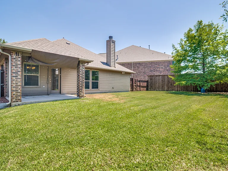 Large fenced backyard with covered patio.