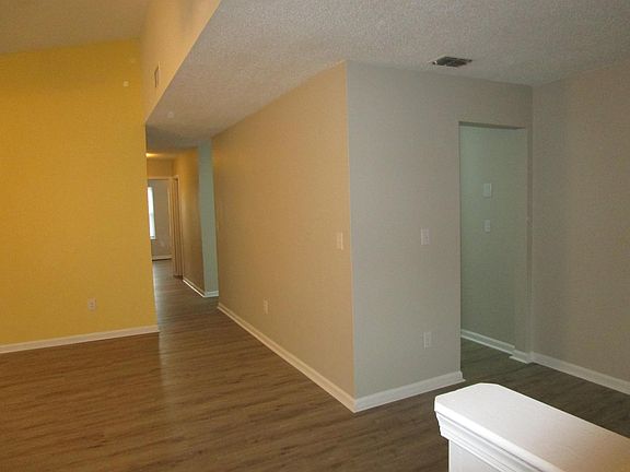 Inside front door looking down hallway, and to the right, looking through dining room to kitchen doorway