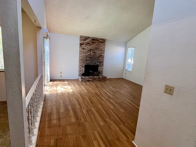 The family/entertaining room features a brick wood fireplace and a wet bar.