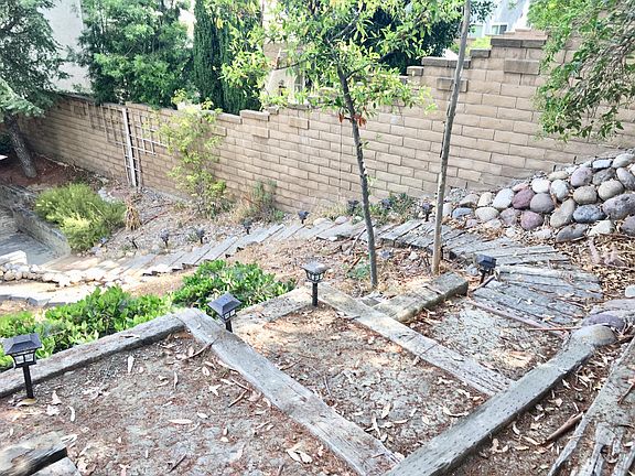 Steps from top of hill down to patio in backyard