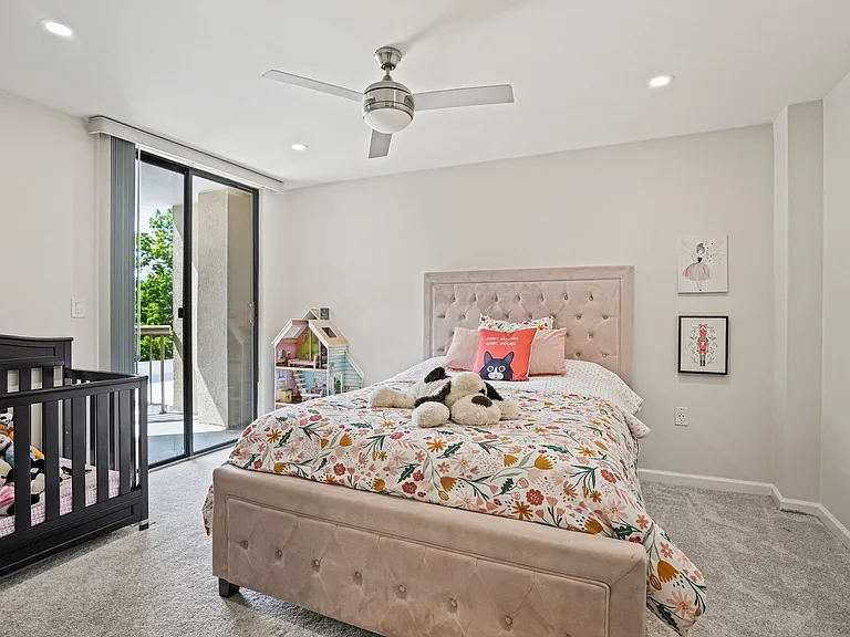 Comfortable bedroom with plenty of natural light, perfect for restful living with convenient outdoor balcony access