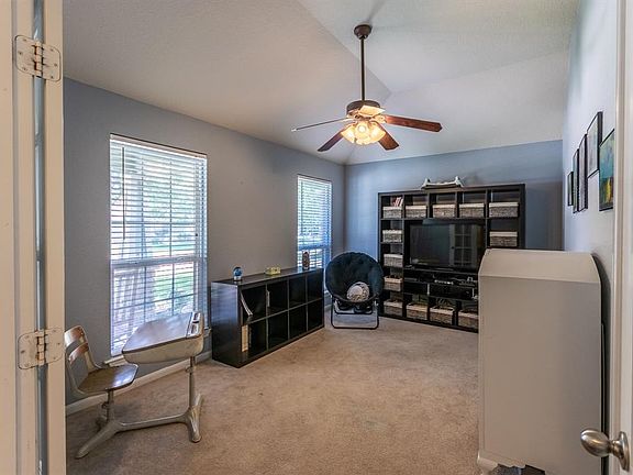 This room makes a great office space or guest bedroom with its windows and tall ceilings letting plenty of natural light flood the room