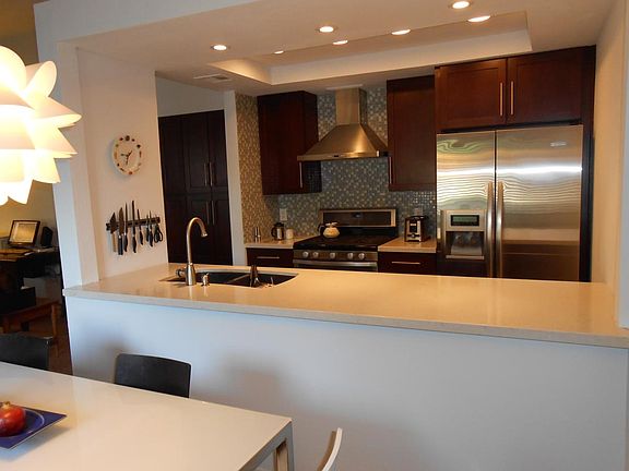 Large pantry left of kitchen quartz counter tops, glass tiled area, white ceiling lite in dining area