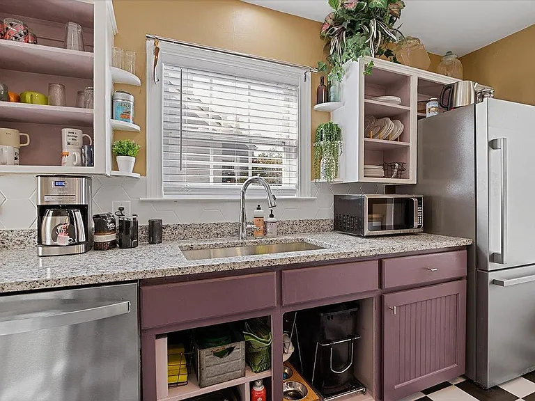Kitchen at Hunsucker's was completely remodeled in 2023 and features stainless appliances and checkerboard tile floor all within walking distance of Downtown and Cone Hospital