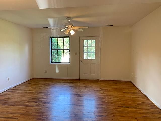 Spacious family room has a ceiling fan, wood floors and access to the rear patio.