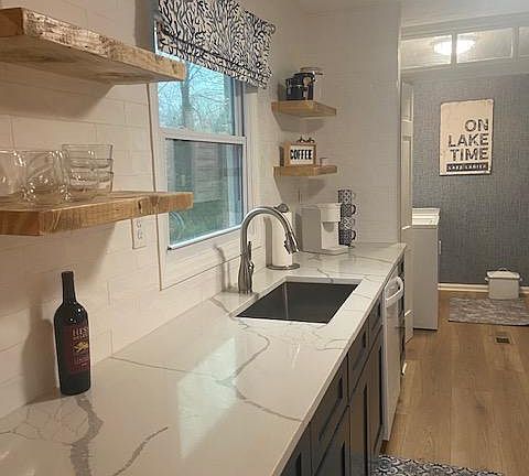 Kitchen, new quartz countertops, open shelving and washer dryer in next room.
