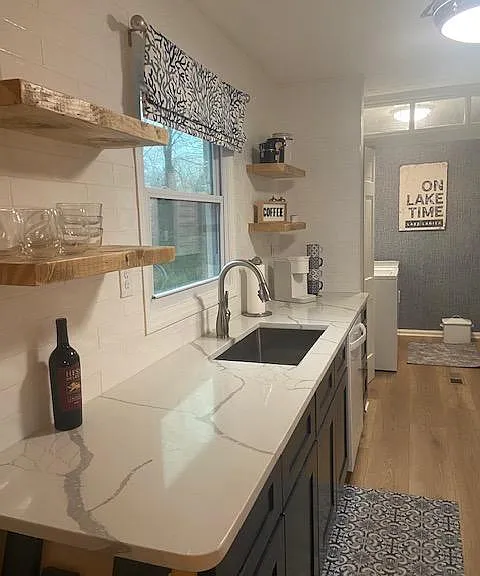 Kitchen, new quartz countertops, open shelving and washer dryer in next room.