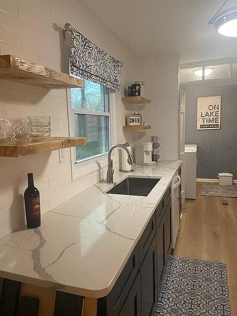 Kitchen, new quartz countertops, open shelving and washer dryer in next room.