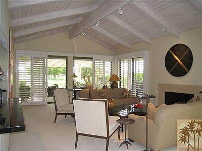 Light and airy beam ceiling living room with marble fireplac