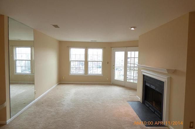 Living room without furniture. Balcony door on the far right.