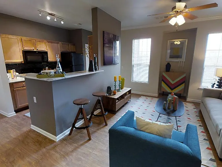 Apartment dining and living room with wood-style flooring.