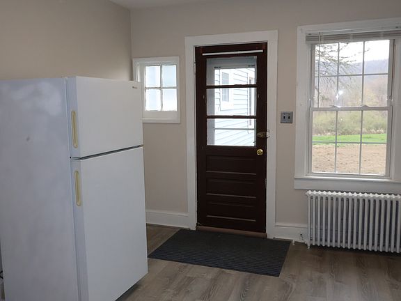 Here's where you walk into the kitchen with the fridge and radiator and as you can see our new floors