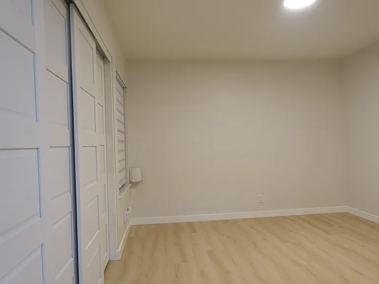 Bedroom #2: Oak flooring and oak ceiling light.