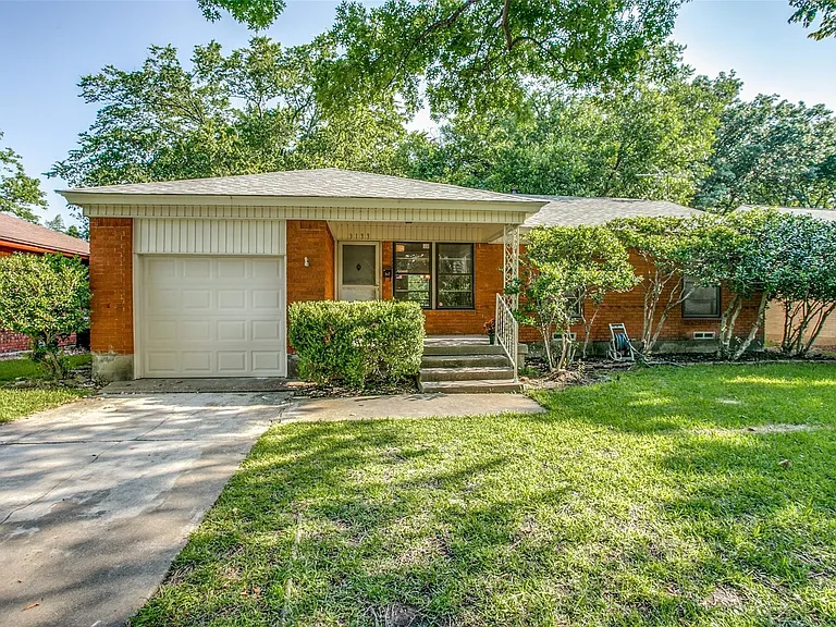Brick exterior residence featuring an attached garage and a concrete driveway