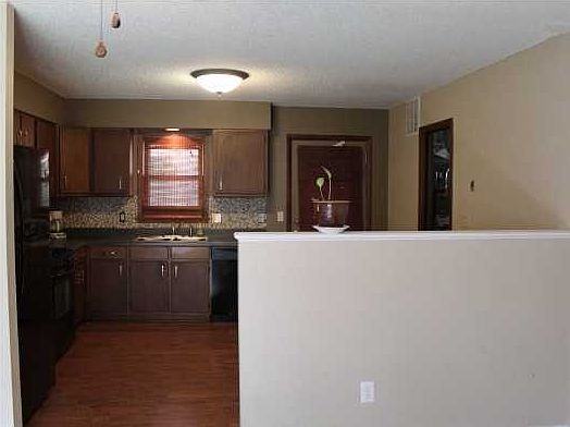 KITCHEN IS OPEN TO THE LIVING ROOM WITH WOOD LAMINATE FLOORING