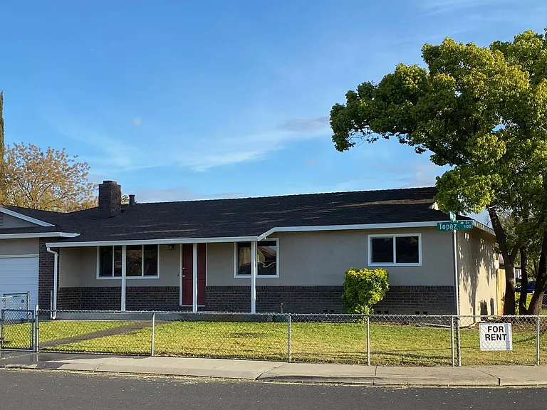 Exterior of home, corner lot, with fence in front yard.