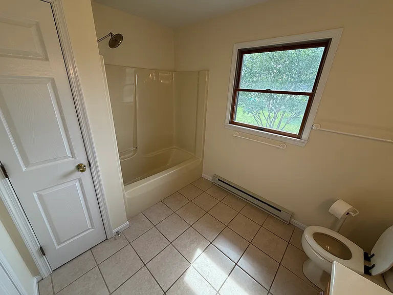 Full bathroom offers storage closet and natural light